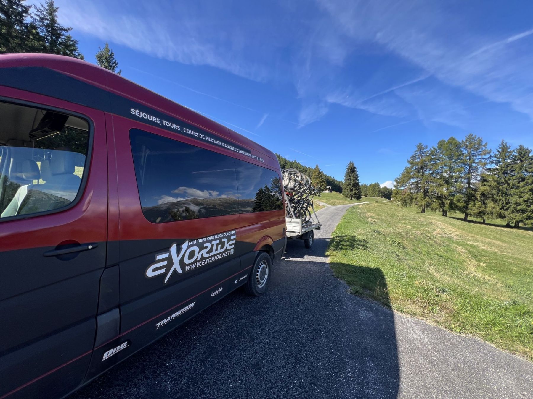 The Exoride van and its loaded trailer on a Valais mountain road, heading for the start of a shuttle day